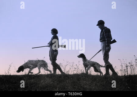 Années 1920 Années 1930, SILHOUETTE ANONYME L'HOMME ET LA FEMME Les chasseurs armés de fusils CHACUN AVEC UN CHIEN DE CHASSE - s2541c har001 HARS SILHOUETTÉ LOISIRS LOISIRS ET CANINES POOCH ANONYME CONNEXION COOPÉRATION CANINE D'ARMES À FEU ARMES À FEU MI-MAMMIFÈRE CHASSEURS HOT MID-ADULT MAN MID-ADULT WOMAN NOIR ET BLANC ENSEMBLE HAR001 old fashioned Banque D'Images