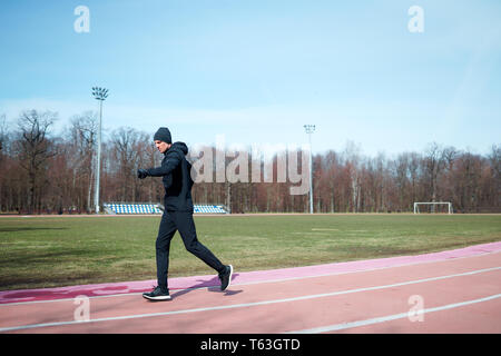 Image de l'homme sportif qui traverse stadium au printemps jog . Banque D'Images