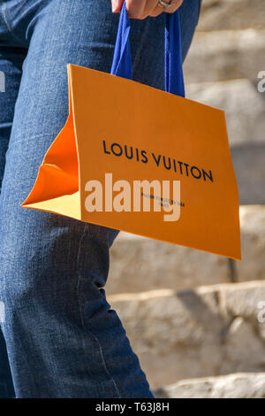 CANNES, FRANCE - Avril 2019 : Personne portant un sac Louis Vuitton après avoir acheté dans le magasin sur le front de mer à Cannes. Banque D'Images