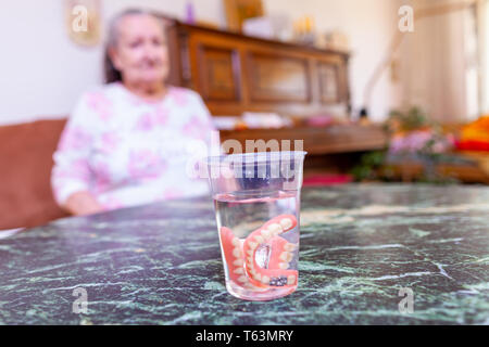 Dentier d'une vieille dame dans un verre d'eau Banque D'Images