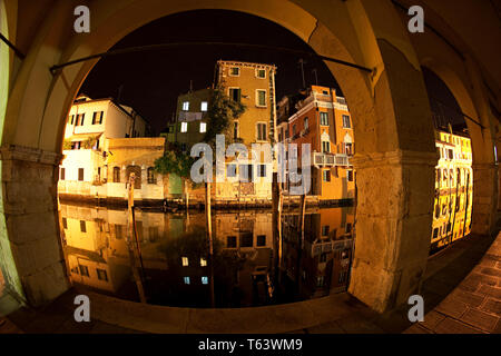 Maisons reflet dans le canal Vena à la nuit avec des poissons cristallin. Chioggia, Venise Italie. Banque D'Images