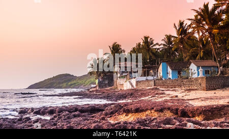 Belle plage d'Anjuna dans le nord de Goa, en Inde. Plage populaire destination vacances à Goa avec bleu de la mer d'Oman, vagues, rochers et plage typique Banque D'Images