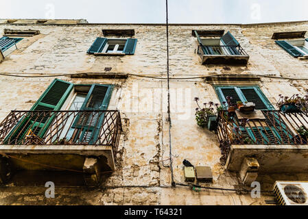 Pigeon perché sur le mur d'une vieille maison abandonnée dans une ville italienne. Banque D'Images