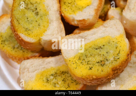 Délicieux avec des tranches de pain à l'ail fromage beurre persil oignon de printemps petit-déjeuner sain sur plaque blanche baguette grillées accompagnement croustillant Banque D'Images