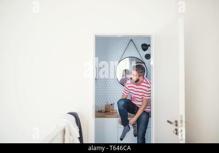 Un adulte homme hipster s'habiller dans brahroom à l'intérieur à la maison. Copier l'espace. Banque D'Images