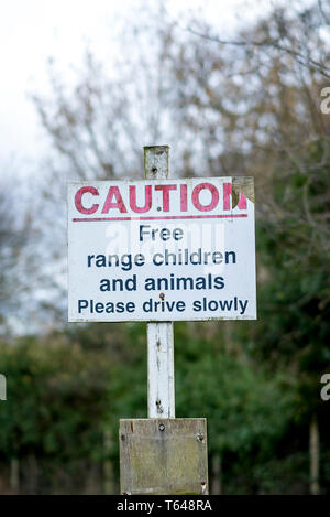 Avis public aux automobilistes d'avertissement Veuillez conduire lentement à cause d'enfants et d'animaux en liberté dans la région. De bons conseils à l'humour britannique ! Banque D'Images