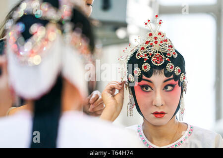 (190429) -- URUMQI, 29 avril 2019 (Xinhua) -- L'actrice Nina Il organise des chapeaux avant d'effectuer, à Urumqi, capitale du nord-ouest de la Chine, la Région autonome du Xinjiang Uygur, 24 avril 2019. Né dans une famille consacrée à l'opéra Qinqiang, un opéra chinois populaire dans le nord-ouest de la Chine, 33 ans, actrice Nina il a joué le rôle d'une jeune femme dans l'opéra à une troupe d'opéra Qinqiang à Urumqi depuis 2005. Au-delà des théâtres, il Nina et ses collègues ont effectué l'opéra dans les communautés et les écoles pour promouvoir la culture de l'opéra traditionnel chinois. Exécution d'oeuvres classiques de l'opéra Qinqiang devraient être adaptés aux Banque D'Images