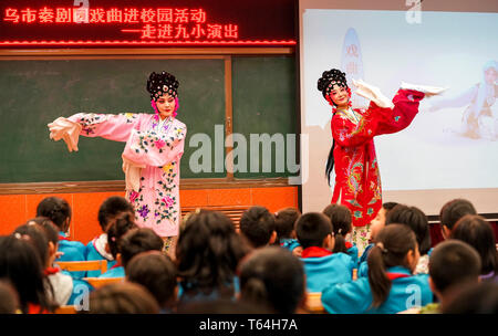 (190429) -- URUMQI, 29 avril 2019 (Xinhua) -- L'actrice Il Nina (R) se produit dans une école primaire à Urumqi, capitale du nord-ouest de la Chine, la Région autonome du Xinjiang Uygur, 25 avril 2019. Né dans une famille consacrée à l'opéra Qinqiang, un opéra chinois populaire dans le nord-ouest de la Chine, 33 ans, actrice Nina il a joué le rôle d'une jeune femme dans l'opéra à une troupe d'opéra Qinqiang à Urumqi depuis 2005. Au-delà des théâtres, il Nina et ses collègues ont effectué l'opéra dans les communautés et les écoles pour promouvoir la culture de l'opéra traditionnel chinois. Exécution d'oeuvres classiques de l'opéra Qinqiang devrait être adaptée à mo Banque D'Images