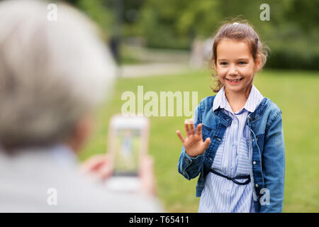 Petite fille d'être photographié à parc d'été Banque D'Images