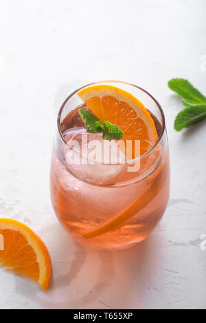 Glace fraîche plateau cocktail à l'orange et de la glace en verre sur fond blanc Banque D'Images