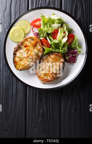 Esturgeon fraîchement préparé servi avec des steaks salade de légumes frais sur une assiette sur la table. Haut Vertical Vue de dessus Banque D'Images