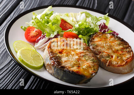L'adjudication de l'esturgeon steaks frites avec salade de légumes frais sur une assiette sur la table horizontale. Banque D'Images