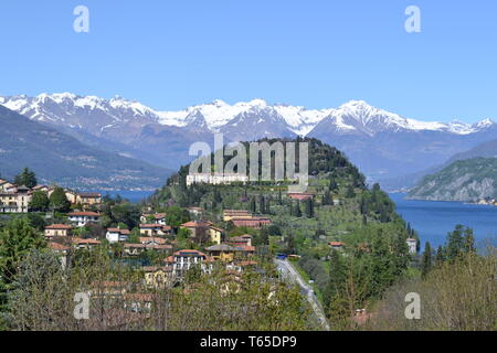 Belle vue sur la péninsule de Bellagio à ressort avec une ville, Alpes européennes avec de la neige sur les sommets et le lac de Côme à partir de la route de Lecco dans une journée ensoleillée. Banque D'Images