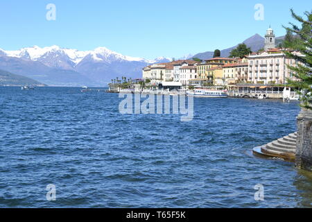 Belle vue de printemps ville de Bellagio au lac de Côme, Banque européenne d'Alpes avec plus de neige pics, ferry se déplaçant dans l'eau bleu du lac de Côme en journée ensoleillée. Banque D'Images