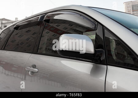 Close-up du côté gauche avec clignotants et la fenêtre de la voiture d'argent sur le corps vus dans la rue après le lavage et en détail Banque D'Images