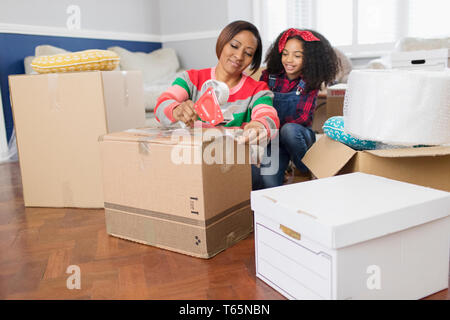 Mère et fille taping, déménagement cartons de déménagement Banque D'Images