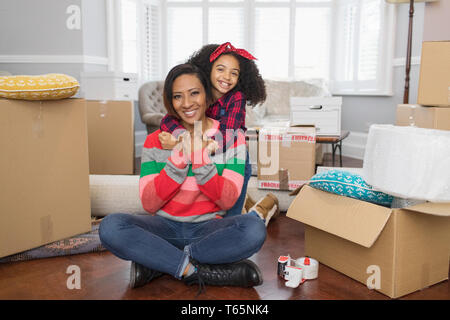 Portrait of happy mother and daughter hugging, déménagement en nouvelle maison Banque D'Images