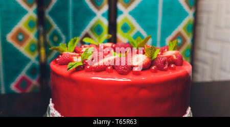 Délicieux gâteau framboise avec fraises, framboises, bleuets, raisins secs et pistaches sur fond de bois. Banque D'Images