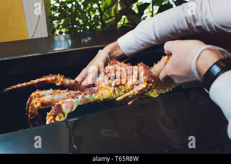 Restaurant Chef cuisinier en uniforme blanc est holding fresh gros crabe du Kamtchatka. Concept de la nourriture saine, de vie, de fruits de mer, de délicatesse, utile, dans le régime alimentaire Banque D'Images