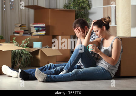 Expulsées triste couple moving home plaint assis sur le plancher dans la nuit Banque D'Images