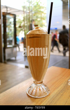 Verre de café frappe sur la table avec la scène de la ville en arrière-plan Banque D'Images