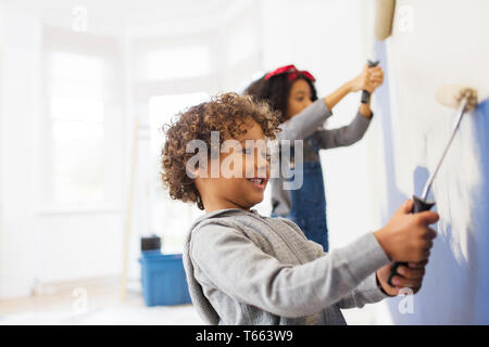 Cute boy painting wall Banque D'Images