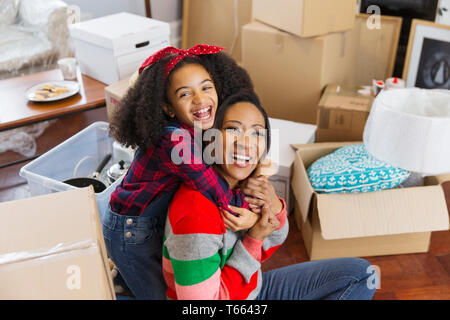 Heureux et enthousiastes Portrait mother and daughter hugging parmi les boîtes, d'un déménagement Banque D'Images