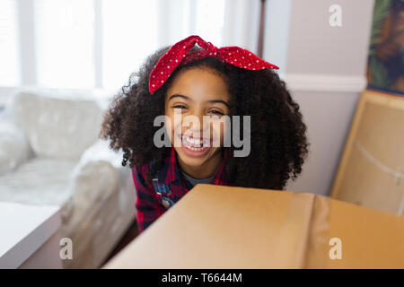 Happy girl Portrait derrière boîte carton, déménagement en nouvelle maison Banque D'Images