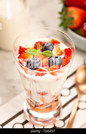 Doux de dessert sain dans le verre avec des fraises, des yaourts et des bleuets. Concept d'aliments sains Banque D'Images