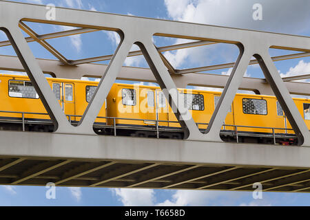 Train en jaune sur un pont de fer avec ciel bleu Banque D'Images