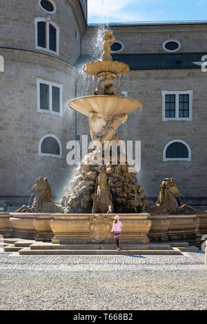 Fontaine Residenzplatz Salzbourg, vue d'un enfant approche de la fontaine baroque situé dans la vieille ville de Salzbourg à Residenzplatz, Autriche. Banque D'Images