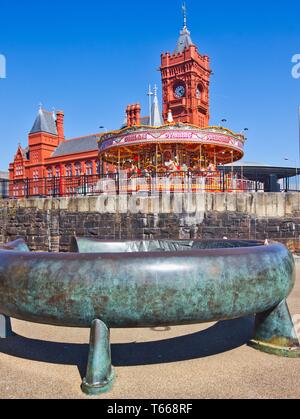 Bague Celtique bronze sculpture avec expositions carousel et le Pierhead building en arrière-plan, la baie de Cardiff, Cardiff, Pays de Galles, Royaume-Uni Banque D'Images