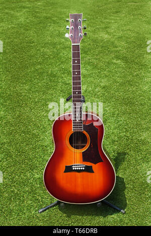 Guitare acoustique sur fond d'herbe verte. Banque D'Images