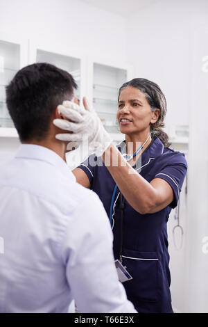 Female doctor examining patient de sexe masculin dans la salle d'examen clinique Banque D'Images