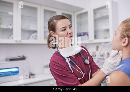 Femme pédiatre examinant fille en salle d'examen clinique Banque D'Images