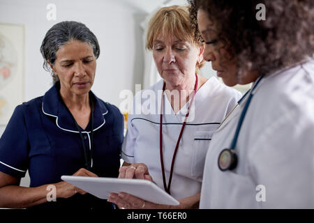 Femme médecin et infirmières using digital tablet in clinic Banque D'Images