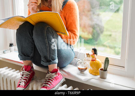 Young female college student studying in window Banque D'Images