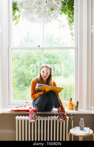 Concentré de jeunes femelles college student studying in window Banque D'Images