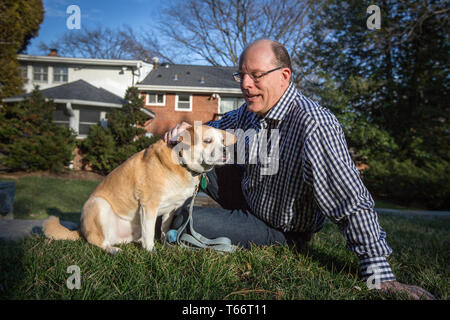 Membre du Centre d'éthique et politique de l'État, Peter Wehner avec le chien de la famille Roméo. Banque D'Images