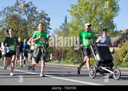 Deux coureurs pousser un grand haut-parleur qui diffuse la musique comme la partie 'pacer', s'exécutant dans le Marathon 2019 Eugene de Eugene, Oregon, USA. Banque D'Images