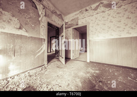 Chambre vide ruineuse avec de vieux papiers peints et filtre couleur sépia Banque D'Images