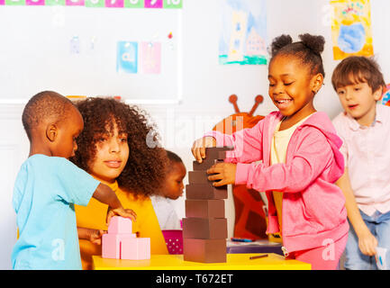 Groupe de petits enfants garçons et filles tour construite en bloc avec la classe d'école maternelle Banque D'Images