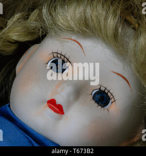 Visage de poupée yeux bleus cheveux blonds cils peints lèvres rouge Banque D'Images