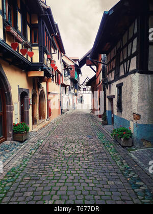 Ruelles de l'ancien village d'Eguisheim avec maisons médiévales à pans de bois le long de la célèbre route des vins en Alsace, France. Banque D'Images