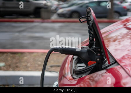 02 avril, 2019 - Emeryville, CA, USA : une prise électrique inséré dans le port de recharge pour voitures électriques. Banque D'Images