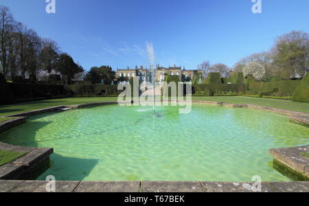 Renishaw Hall and Gardens vu de la piscine par le biais de couverture topiaires d'if( Taxus baccata) au printemps, Derbyshire, Angleterre, RU Banque D'Images