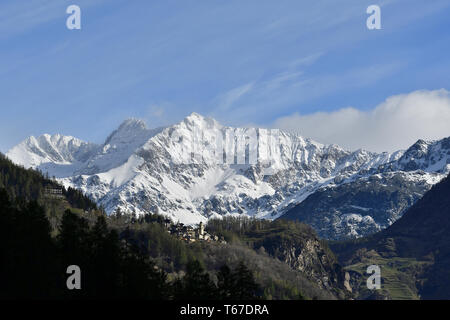 Primolo est un petit groupe de maison à Chiesa in Valmalenco ville. La vue montre Primolo et son église avec gamme de fixation de Valmalenco, avec de la neige fraîche Banque D'Images