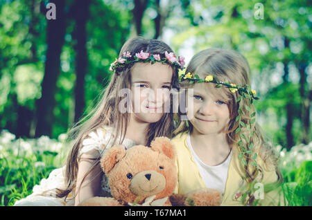 Deux belles filles assis ensemble dans le pré Banque D'Images