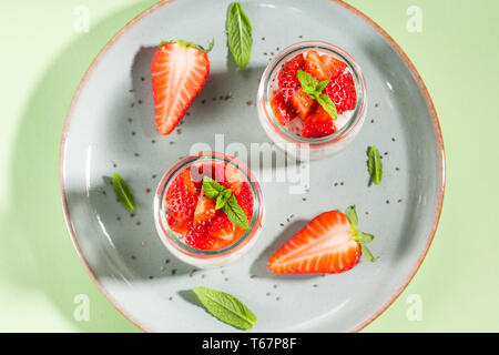 Parfait granola yogourt aux fraises et chia seeds. Délicieux dessert sain pour le petit déjeuner. Lumineux vert menthe spring summer background Banque D'Images