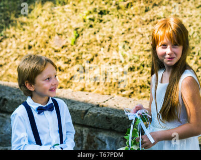 Porteur d'anneau et la fille de fleur de mariage au jardin d'été Banque D'Images